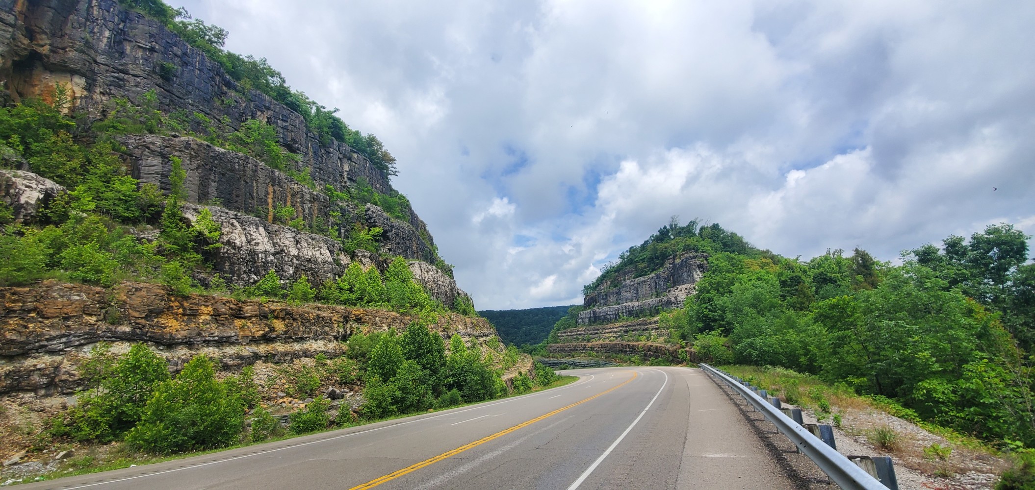 An impressive road cut on both sides of the road.
